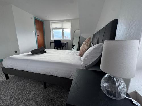 a bedroom with a large bed with a lamp at Florence 4 Bedroom house, sleeps 14 in Killingbeck