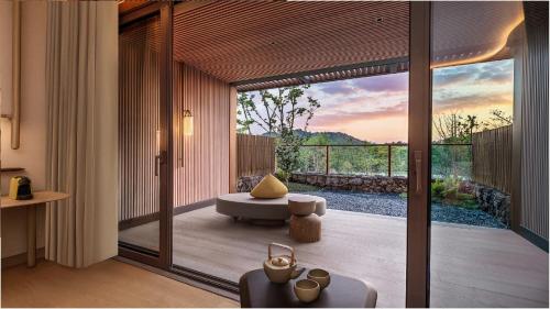 a room with a balcony with a view of the sunset at Hotel Indigo Anji in Anji