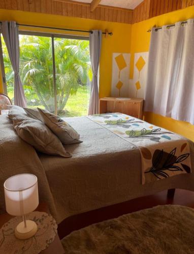 a bedroom with a large bed with a window at Cabañas Rapanui keka in Hanga Roa
