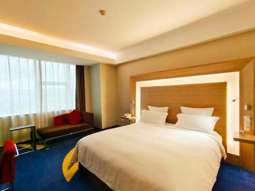 a hotel room with a large bed and a window at Shenzhen Novotel Watergate in Shenzhen