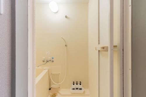 a small bathroom with a shower and a sink at 貝塚GoodStay in Fukuoka