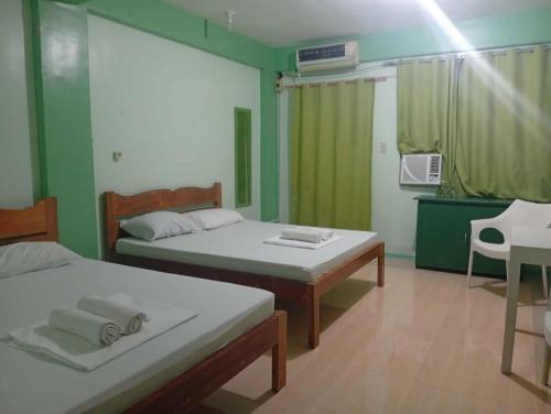 a room with two beds and a table in it at Evashore Beach Resort in Limasawa Island