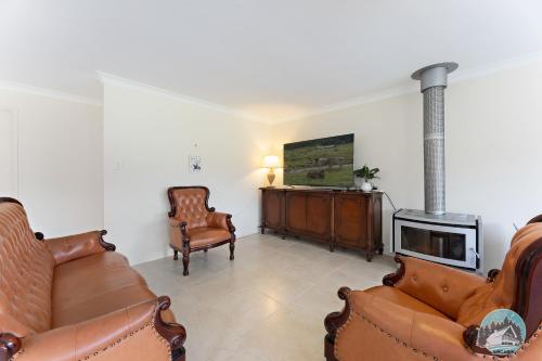 - un salon avec un canapé et un poêle à bois dans l'établissement Aircabin - Wyong Creek - Cozy Country Home, à Yarramalong