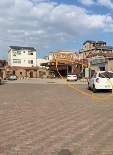 a white car is parked in a parking lot at 大橋旁民宿 in Jincheng