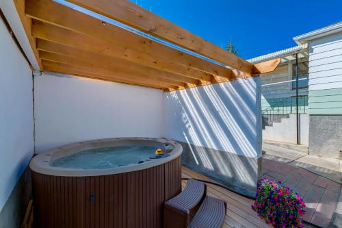 a hot tub on a deck with a pergola at Ramsay Retreat Spa Vibes Hot Tub & Skyline Views in Calgary
