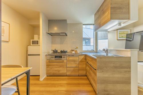 Una cocina con gabinetes de madera y un fregadero. en 7 min walk from JR Yamanote Line Uguisudani Spacious 4-Bedroom House near Ueno & Asakusa With Parking, en Tokio
