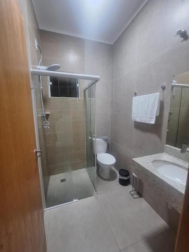 a bathroom with a shower and a toilet and a sink at Regente Feijó Centro in Regente Feijó