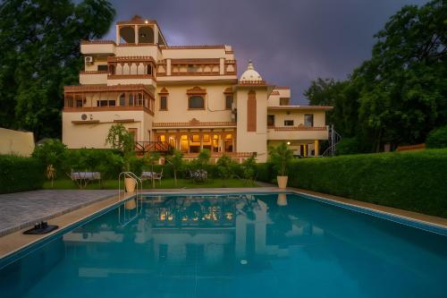 Una casa grande con piscina delante de ella. en The Lavitra Lakeview Hotel, en Udaipur