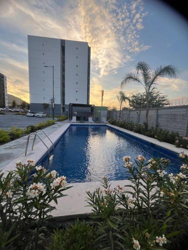 a large swimming pool in front of a building at New furnished apartment near BBVA Stadium in Monterrey