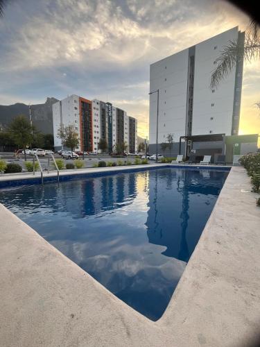 a large swimming pool in a city with buildings at New furnished apartment near BBVA Stadium in Monterrey