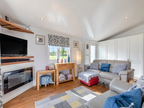 a living room with a couch and a fireplace at Lilac Tree Lodge in Willington