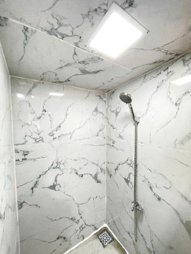 a bathroom with white marble walls and a shower at Mekong Camping Deluxe in Ấp Thanh Sơn (1)