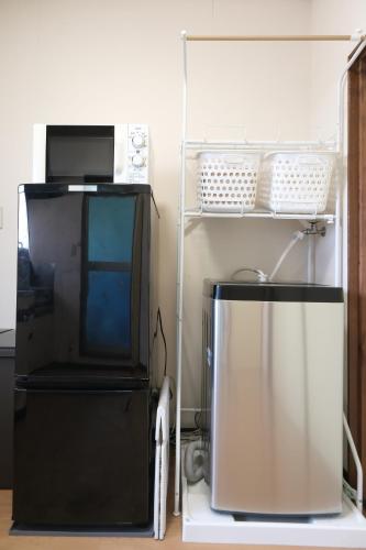 a microwave oven sitting on top of a refrigerator at Private 1K Flat with 2 Single beds and sofa-bed, Near Tokyo & Quiet Area, 202 in Tokorozawa