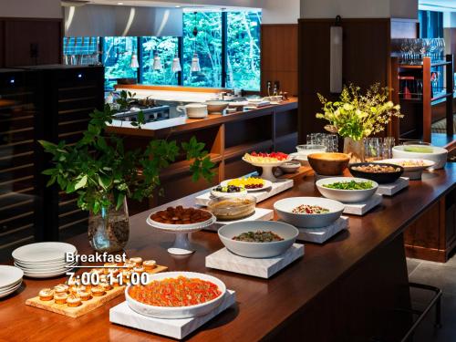 a buffet with bowls of food on a table at Mitsui Garden Hotel Kyoto Sanjo PREMIER in Kyoto