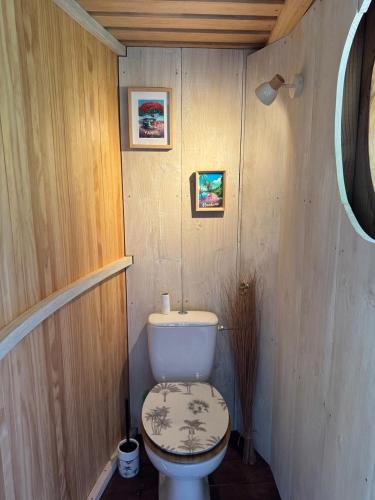 a bathroom with a toilet in a wooden wall at Raiatea Treelodge in Taoru