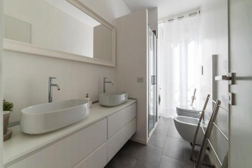 a white bathroom with two sinks and a mirror at FLIX Tre in Rome