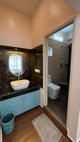 a bathroom with a sink and a toilet and a mirror at Villa19, ECR in Tirupporūr