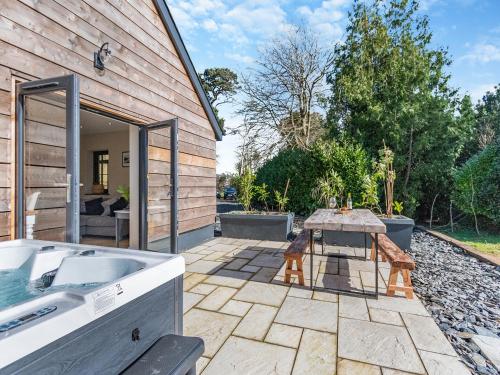 a patio with a tub and a table next to a building at Bwythyn Cudd in Manortown
