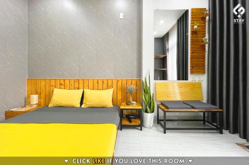 a bedroom with a yellow bed and a bench at FSTAY - COZY AND PEACEFUL HOMESTAY DA NANG in Da Nang