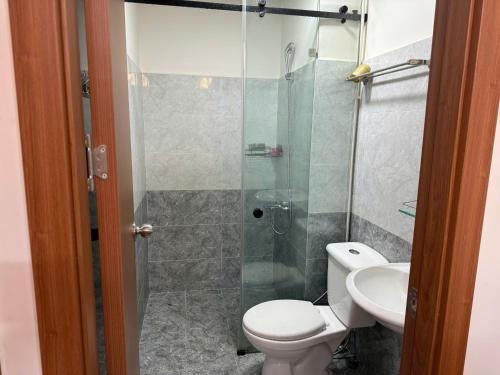 a bathroom with a shower and a toilet and a sink at Sun House in Kinh Dinh