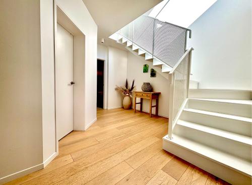 a hallway with a staircase in a house at Deluxe Downtown Mount Maunganui in Mount Maunganui