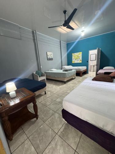 a bedroom with two beds and a blue wall at Casa Pelíkano Uvita in Uvita