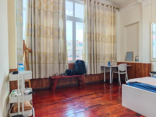 a bedroom with a bed and a table and a window at Khai Homestay in Hanoi