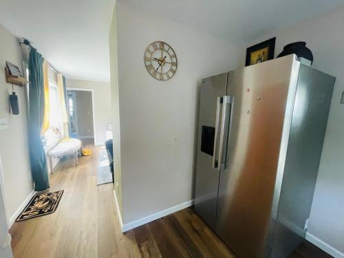 a kitchen with a refrigerator and a clock on the wall at Private Estate, walk to Princeton downtown, 3 Bedrooms, 2 Bath, with Free Parking in Princeton