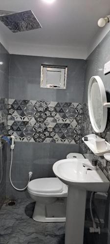 a bathroom with a white toilet and a sink at Shara HomeStay in Trincomalee