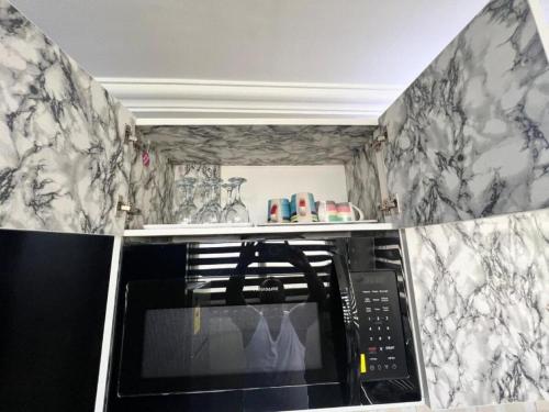a kitchen with black and white marble walls at The Nobles Luxurious 2 Bedroom Apartment in Kumasi