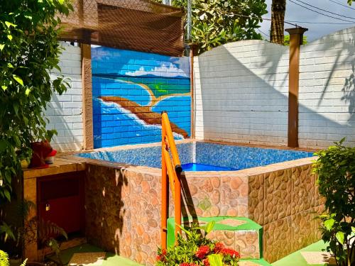 a swimming pool with a painting on the side of a building at Villas Ela en Bahía Ballena,Uvita Hermosas habitaciones privadas grandes, piscina, cocina, jacuzzi, aire acondicionado, tv y baño privado in Uvita