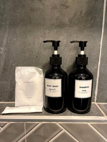 two bottles of soap and a bag on a shelf at The Target Hotel chaingrai in Chiang Rai