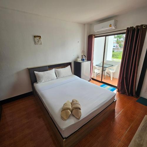 a bedroom with a bed with two slippers on it at Secrets - Pattaya in Pattaya