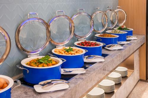 a buffet line with bowls and plates of food at Novotel Shanghai Hongqiao International Airport in Shanghai