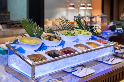 a buffet with bowls of food on a table at Novotel Shanghai Hongqiao International Airport in Shanghai