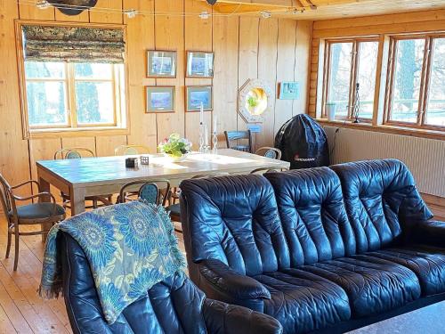a living room with a leather couch and a table at Lakeview Cottage Retreat-By Traum in Gränna