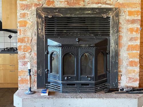 a black fireplace in a brick wall in a kitchen at Lakeview Cottage Retreat-By Traum in Gränna