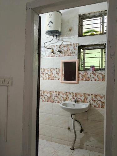 a bathroom with a sink and a mirror at Shimray's Minimalist Hostel in Guwahati