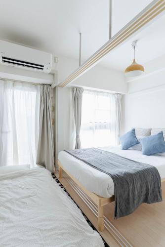 a bedroom with two beds and a window at Yakuin apartment in Fukuoka
