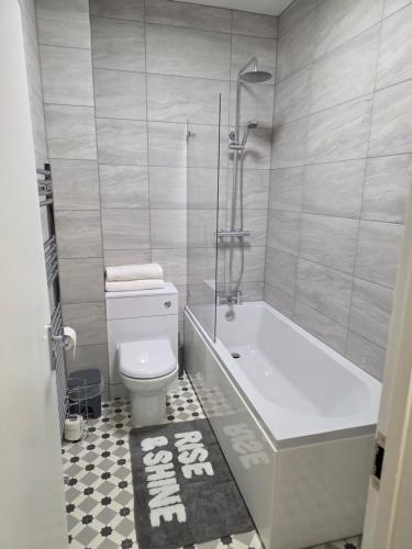 a bathroom with a tub and a toilet and a shower at Cozy one bedroom flat in Chatham