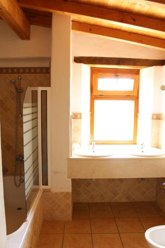 a bathroom with two sinks and a window at Quinta Pedagogica da Samoqueirinha - Duna Parque Group in Vila Nova de Milfontes