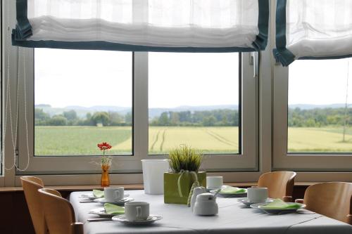 a dining room with a table with chairs and windows at Hotel Schwanau garni in Schwanau