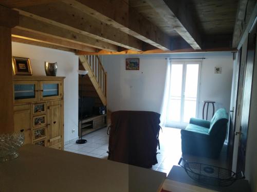 un salon avec un escalier et une chaise bleue dans l'établissement Appartement Anatole France, à Saint-Gilles