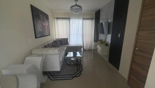 Una sala de estar con un sofá blanco y una mesa. en El hogar ideal para tu estancia, en Santo Domingo