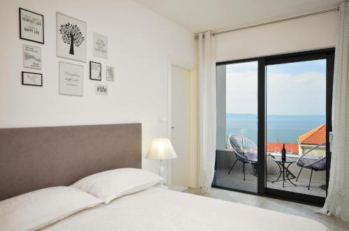 a bedroom with a bed and a view of the ocean at Villa Nina 1 Makarska in Makarska