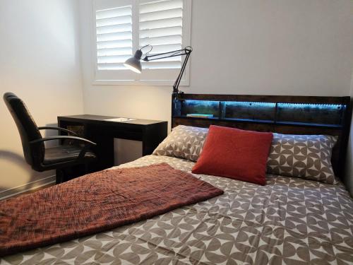 a bedroom with a bed with a red pillow and a desk at Semi-Private Townhouse - 3 Bedrooms - 4 beds - Free Parking, Wifi, Netflix in Toronto