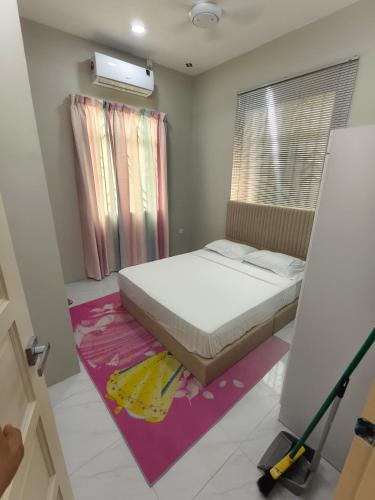 a bedroom with a bed and a purple rug at Serai Homestay in Dungun