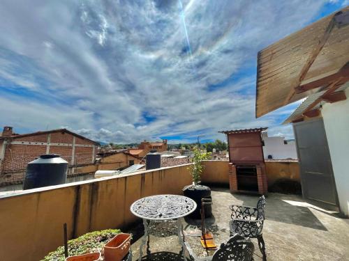 a patio with a table and chairs on a balcony at Casa del Sol in Pátzcuaro