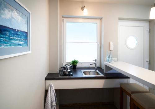 a kitchen with a sink and a window at Im-Jaich Boardinghouse Bremerhaven in Bremerhaven