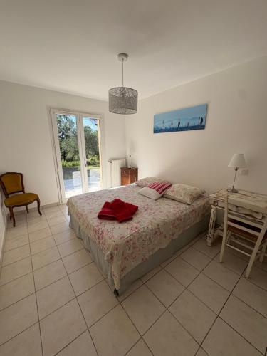 une chambre avec un lit, une table et une fenêtre dans l'établissement Villa provençale dans le Golfe de Saint Tropez, à Grimaud
